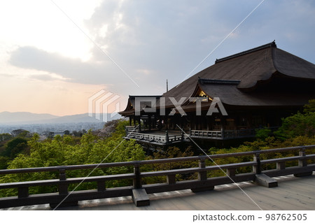 日本京都，春天的清水寺，被稱為清水舞台的主殿，美麗的日落和城市景觀，建築物和新鮮的綠色植物在斜光下閃耀著金色 98762505