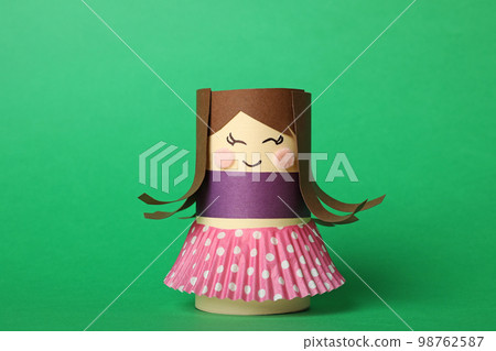 Toy doll made of toilet paper hub on green background 98762587