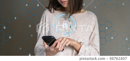 Girl holds a mobile phone and takes care of data security. Girl holds a mobile phone and takes care of data security. 98762807