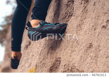 Woman is climbing, training on the mountains, feets closeup. 98762811