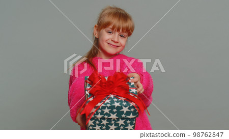 Lovely smiling preteen child girl kid presenting birthday gift box offer wrapped present celebrating Lovely smiling preteen child girl kid presenting birthday gift box offer wrapped present celebrating 98762847