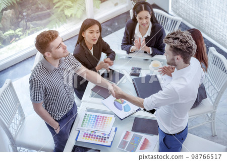 Team Business Partners shaking hands together to Greeting Start up small business in meeting room. Shakehand teamwork partners at modern office handshake together. Business mergers and acquisitions 98766517