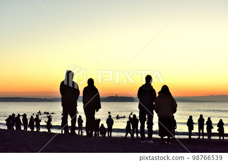 Silhouettes of people on the beach welcoming the first sunrise of the year 98766539
