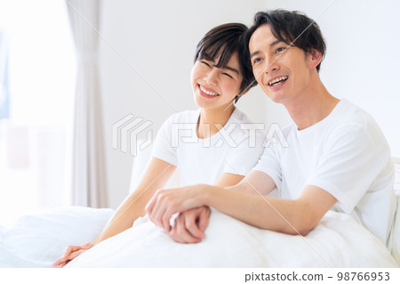 Husband and wife couple family bedroom lifestyle morning 98766953