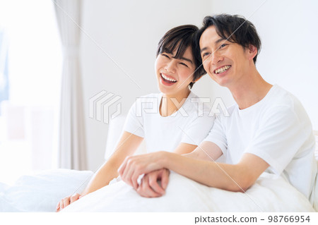 Husband and wife couple family bedroom lifestyle morning 98766954