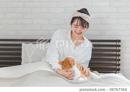 在房子的臥室/臥室裡喜歡貓和寵物的女主人(會說話) 在房子的臥室/臥室裡喜歡貓和寵物的女主人(會說話) 98767368