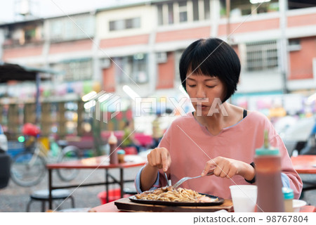 woman eat Taiwanese night market steak 98767804