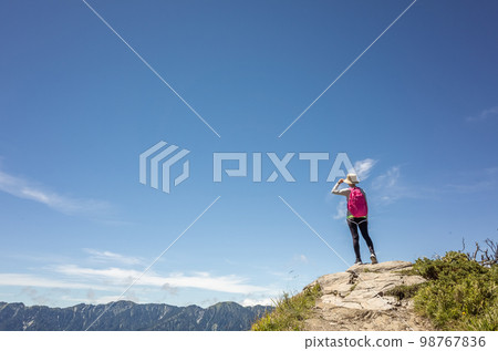 Asian mountain climbing woman pointing at far away 98767836