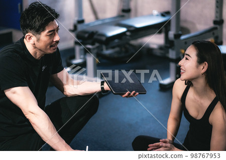 Personal trainer and woman doing counseling at the gym 98767953