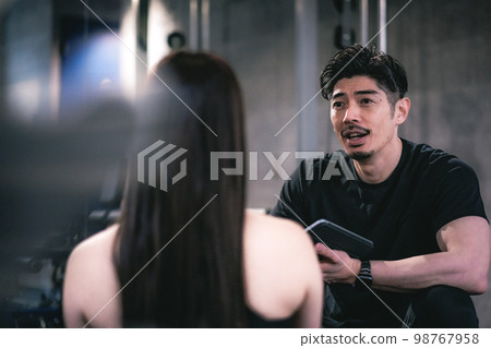 私人教練和在健身房做諮詢的女人 私人教練和在健身房做諮詢的女人 98767958