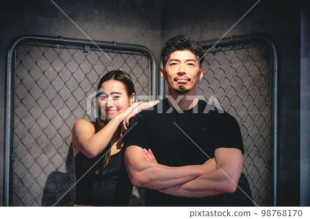 在鐵絲網前擺姿勢的男人和女人 在鐵絲網前擺姿勢的男人和女人 98768170