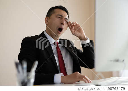 Sleepy/tired businessman in the office 98768479