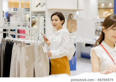 Woman enjoying shopping at an apparel store Woman enjoying shopping at an apparel store 98769874