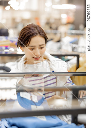Apparel product A woman neatly folding her clothes Apparel product A woman neatly folding her clothes 98769883
