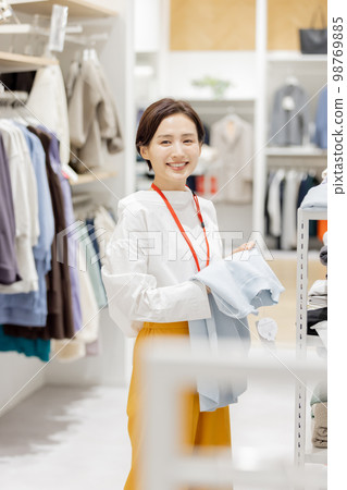 Apparel product A woman neatly folding her clothes Apparel product A woman neatly folding her clothes 98769885
