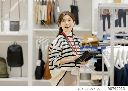 Apparel store clerk managing inventory Apparel store clerk managing inventory 98769913