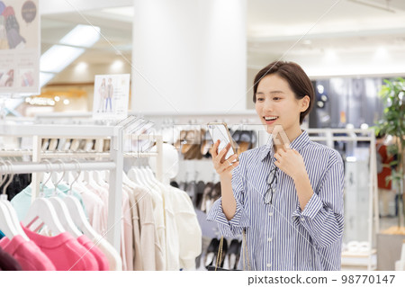Woman enjoying shopping in a boutique Woman enjoying shopping in a boutique 98770147