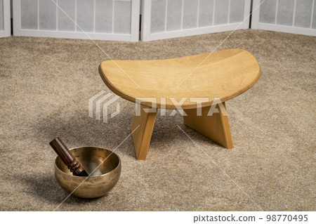 Tibetan singing bowl and meditation, kneeling bench to sit in a natural, balanced and relaxed posture Tibetan singing bowl and meditation, kneeling bench to sit in a natural, balanced and relaxed posture 98770495