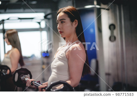 woman doing arm exercises at the gym woman doing arm exercises at the gym 98771583