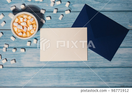 Empty greeting or invitation card mock up blue envelope with white cup of coffee and marshmallows on wooden blue background. Blank paper copy space for your text. Valentines day, Happy fathers mothers Empty greeting or invitation card mock up blue envelope with white cup of coffee and marshmallows on wooden blue background. Blank paper copy space for your text. Valentines day, Happy fathers mothers 98771912