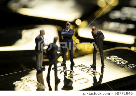 Image of miniature business person and gold nuggets Image of miniature business person and gold nuggets 98771946