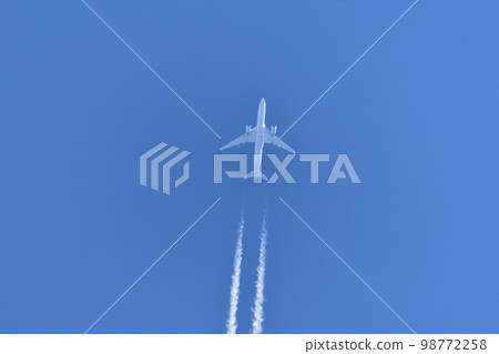 Jet plane and contrails flying in the blue sky 98772258