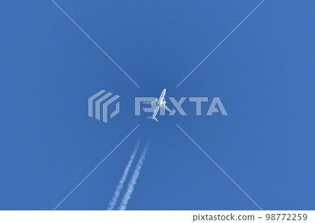 Jet plane and contrails flying in the blue sky 98772259