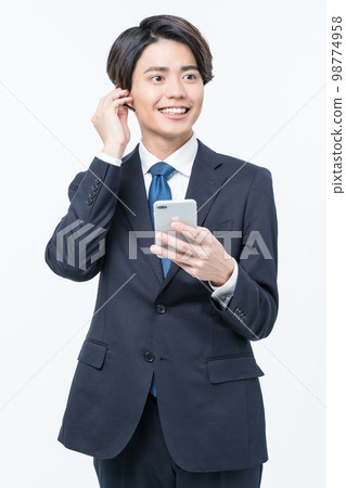 A young man in a suit making a phone call 98774958