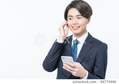 A young man in a suit making a phone call 98774996