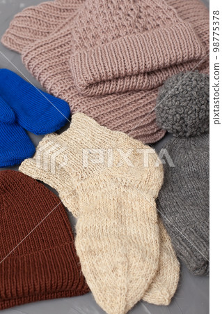 knitted brown baby romper and nipple, pink hat and toy on warm knitted blanket. autumn set of baby clothes. top view and flat lay knitted brown baby romper and nipple, pink hat and toy on warm knitted blanket. autumn set of baby clothes. top view and flat lay 98775378