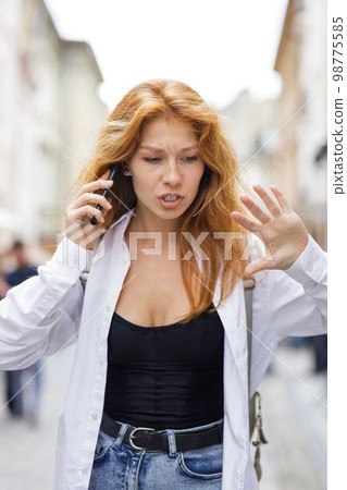 Young redhead woman shouting on the phone dealing with some problems 98775585