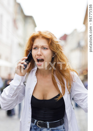 Young redhead woman shouting on the phone dealing with some problems 98775586
