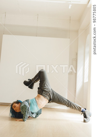 Vertical image of caucasian female hip hop dancer practicing at dance studio with copy space Vertical image of caucasian female hip hop dancer practicing at dance studio with copy space 98775805