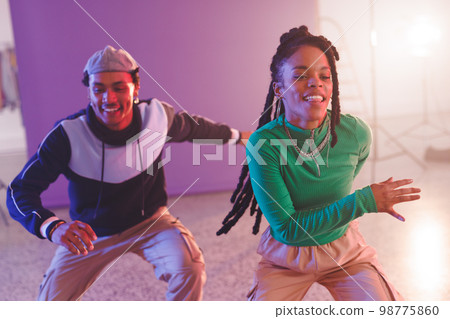 Image of happy diverse female and male hip hop dancers in studio 98775860