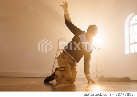 Image of biracial male hip hop dancer dancing in smoked interior 98775892