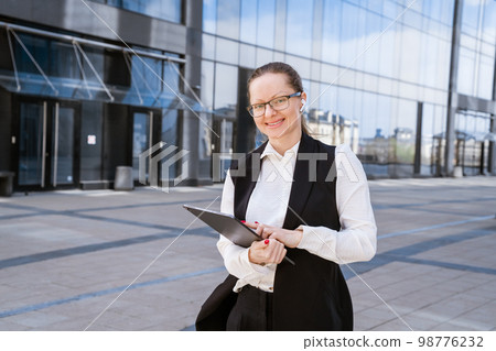 Portrait of successful business woman in stylish suit using laptop posing next Portrait of successful business woman in stylish suit using laptop posing next 98776232