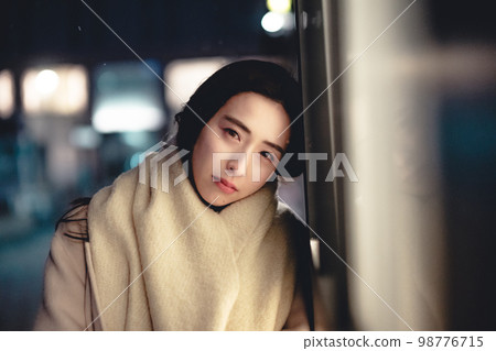A woman with a sorrowful expression in the city at night 98776715