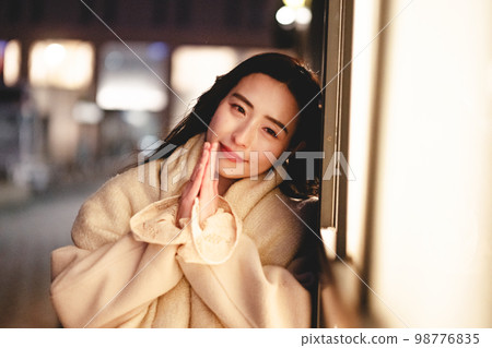 A woman waiting for a date in the night town 98776835