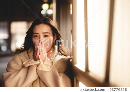 A woman waiting for a date in the night town 98776838