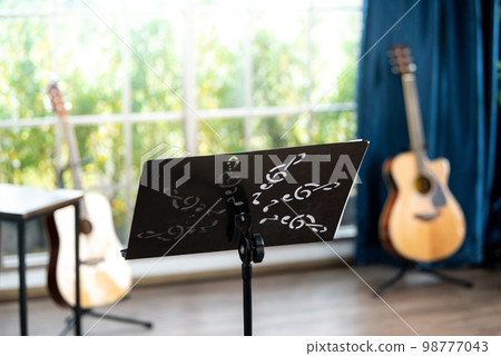 Young woman plays the universal musical instruments in room at home. Pretty young woman study to play musical instruments. Young woman plays the universal musical instruments in room at home. Pretty young woman study to play musical instruments. 98777043