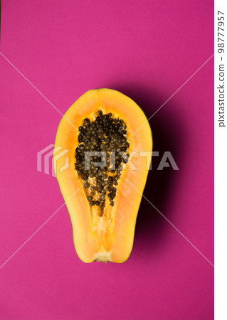 Ripe juicy papaya fruit cut in half on a bright background Ripe juicy papaya fruit cut in half on a bright background 98777957