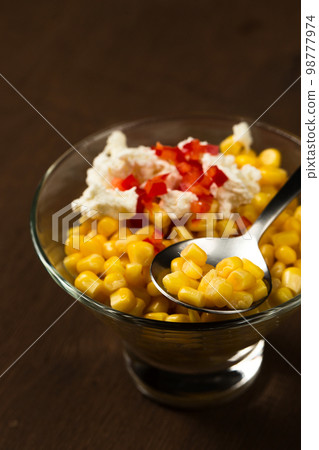 Esquites or Trolley with corn, cheese, mayonnaise and chili. Mexican street food. Close-up Esquites or Trolley with corn, cheese, mayonnaise and chili. Mexican street food. Close-up 98777974