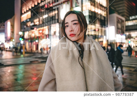 Snowy night city and woman 98778387