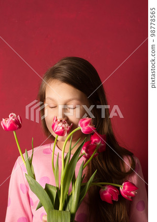 A girl sniffs tulips A girl sniffs tulips 98778565