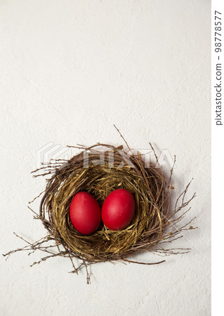 red eggs in the bird's nest on a white background red eggs in the bird's nest on a white background 98778577