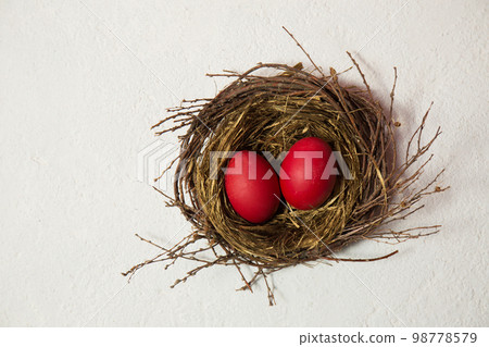 Big red eggs in the bird's nest on a white background Big red eggs in the bird's nest on a white background 98778579