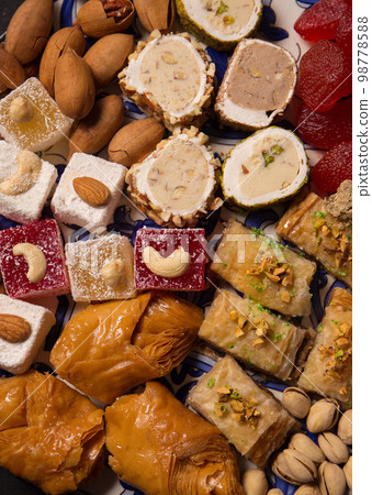 A various oriental sweets and nuts on a dark background, close up 98778588
