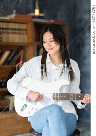 Young woman portrait (electric guitar) 98778763