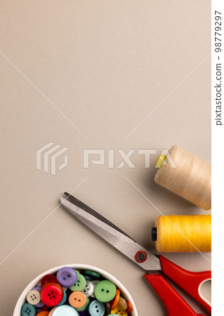 Image of close up of scissors, buttons and threads and copy space on cream background Image of close up of scissors, buttons and threads and copy space on cream background 98779297