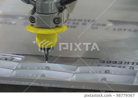Close-up scene of multi-axis abrasive waterjet cutting machine cutting the aluminum plate. Close-up scene of multi-axis abrasive waterjet cutting machine cutting the aluminum plate. 98779367